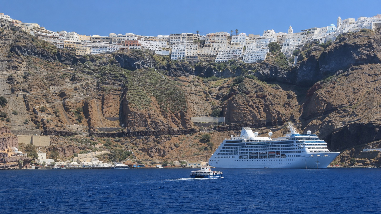 Santorini cliffs and a cruise ship across deep blue Mediterranean water